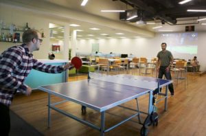 Picture of employees playing table tennis in office amenities space